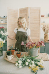Flower shop. Girl florist makes a beautiful spring bouquet