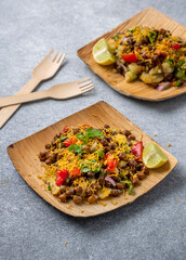 kala chana chaat with boiled potato, onion, tomato with lemon on a bamboo plate 