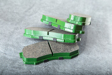 a set of new green brake pads on a gray table