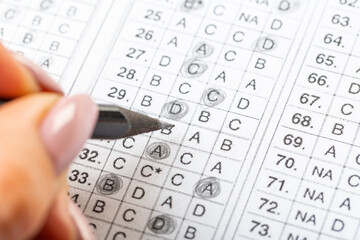 The student fills in the answers to the test in the exercise and examination paper with a pencil. education concept.