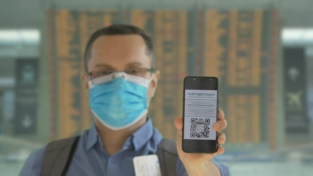 Tourist scanning digital health passport on phone in airport, free travel mobility during COVID-19 pandemic lockdown