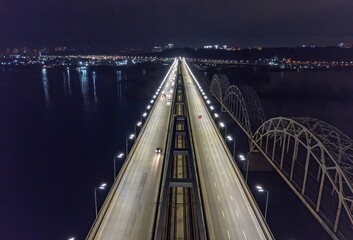 Automobile and railway bridge in Kiev. Night illumination of the bridge. Aerial drone view.