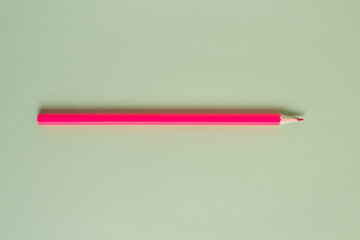 Pink pencil on gray background close up