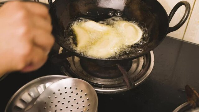 An Indian woman preparing and deep frying gujia, an Indian popular snack especially made in Holi festival of colors