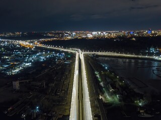 Automobile and railway bridge in Kiev. Night illumination of the bridge. Aerial drone view.