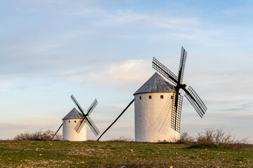 Fototapeta na wymiar two whitewashed traditional Spanish windmills on the plains of La Mancha