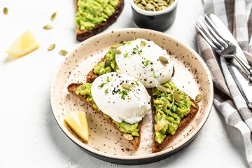 healthy breakfast or snack, Sandwich with avocado and poached egg. Food recipe background. Close up