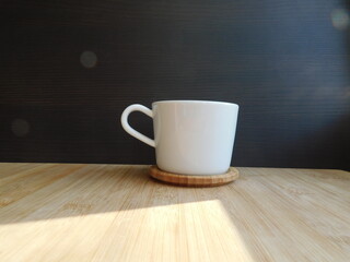 Cup of coffee on wooden table, top view.