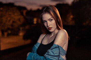 beatiful model girl doing posing and doing faces outside at sunset wearing a blue jacket