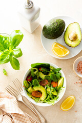Heathy food salad bowl. Avocado spinach salad with lemon juice and olive oil.