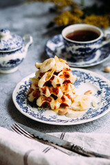 Belgian waffles with banana and honey on a vintage blue plate