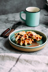 Belgian waffles with banana and honey on a turquoise plate