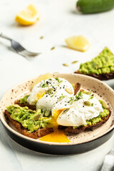 Healthy breakfast whole wheat toasted bread with avocado and poached egg. Breakfast with vegetarian food, healthy diet concept