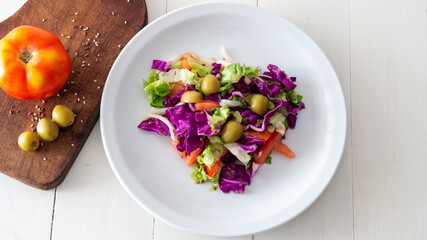 Flat lay view of a fresh mediterranean style salad, placed on top of a white table