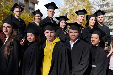 Obraz premium Group of diverse international graduating students celebrating