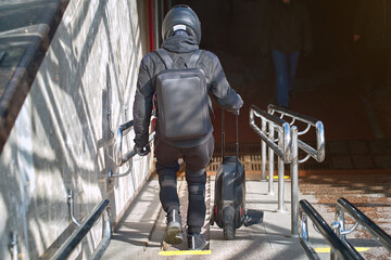 Man with monowheel scooter on stairs. Obstacle for personal electric transport. Man carry unicycle...