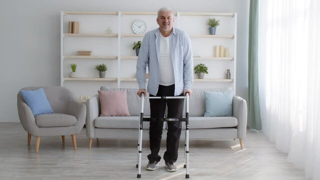 Disabled Man Making Step With Disability Walking Frame At Home