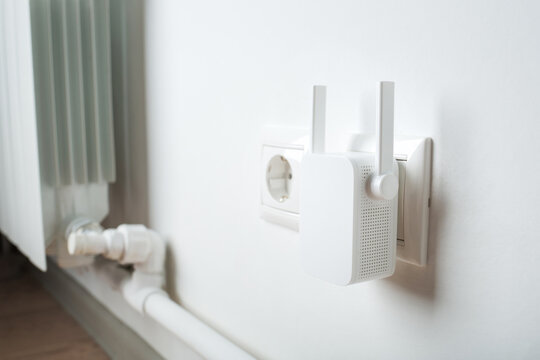 White Wi-fi Repeater Indoors At Home In Outlet. Wireless Router