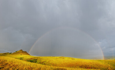 Thunderstorm with clouds and rain and rainbow Tarpig Khakassia park with sun