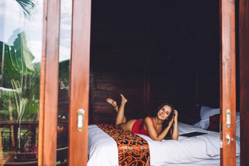 Serene woman lounging on bed in hotel room