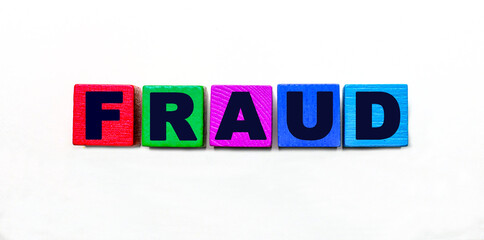 The word FRAUD is written on colorful cubes on a light background