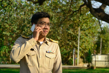 A Thai government officer, Civil servant is making a phone call.