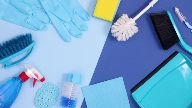 Household cleaning sanitary tools make frame with copy space on dark and bright blue background. Stop motion