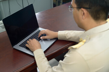 Blurred focus on a Thai government officer, Civil servant and focus on using a laptop keyboard.