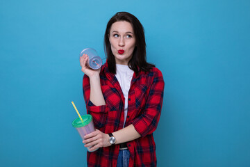 A young woman in a red shirt holds two cocktail glasses