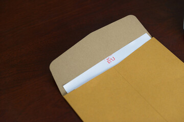 Open the envelope, Translation Thai text "secret" stamped with red ink in the top middle of the white paper.
