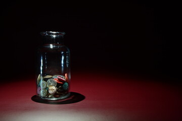 Glass bottle with buttons inside.