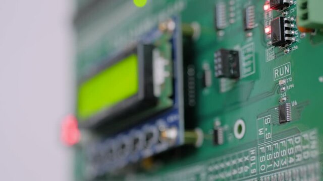 Green printed circuit board - pcb for elevator with digital display module at lift exhibition, trade show - close up view. Technology and electronic concept