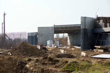 Obraz premium Construction site with a new concrete structure of the building under construction and earthworks,