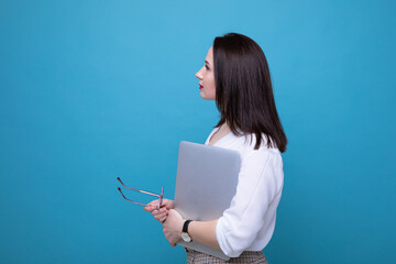 Portrait of a business woman with a laptop on a blue background