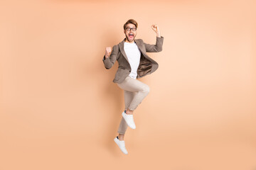 Fototapeta na wymiar Full body profile side photo of attractive happy crazy man jump up air celebrate win isolated on beige color background