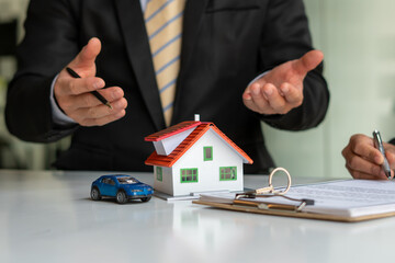 The real estate agent is explaining the house style to the clients who come to contact to see the house design and the purchase agreement.