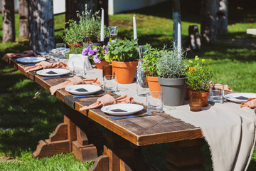 Fototapeta na wymiar Banquet tables in nature. Wedding in the garden. Outdoor wedding. Buffet. Wedding banquet in nature.Festive table serving dishes stands on green grass. table compositions, glasses, candles and plates 