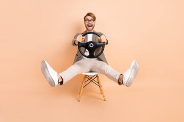 Full size photo of happy excited crazy attractive man in glasses riding car fast extreme isolated...