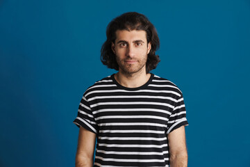 Fototapeta premium Unshaven brunette man in striped t-shirt looking at camera