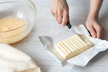 Female hands slicing butter for homemade baking