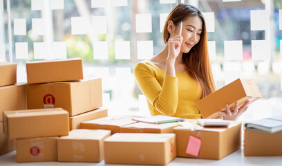 Portrait of Starting small businesses SME owners female entrepreneurs working, box and check online orders to prepare to pack the boxes, sell to customers, sme business ideas online.