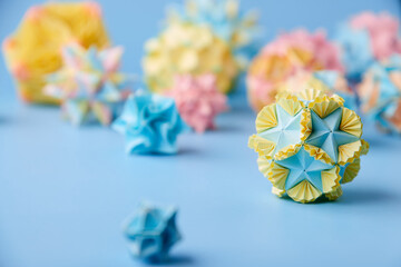 Set of multicolor handmade modular origami balls or Kusudama Isolated on blue background. Visual...
