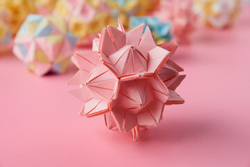 Set of multicolor handmade modular origami balls or Kusudama Isolated on pink background. Visual...