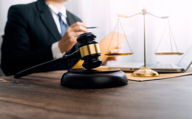 Justice and law concept.Male judge in a courtroom with the gavel, working with, computer and...