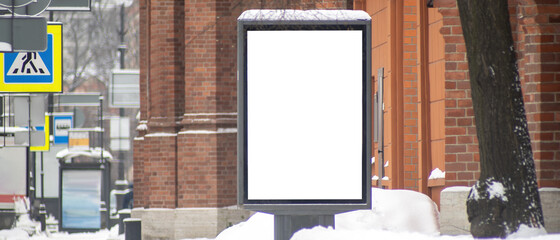 Billboard vertical in the city. With snow in winter.