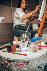 Beautiful talented female artist painting at her home.