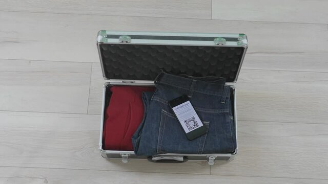 Hands arranging the luggage for travel including the digital health certificate