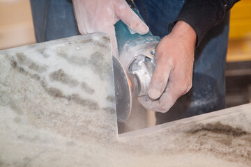 Man making vertical cut with electric hand saw during align marble kitchen countertop at...