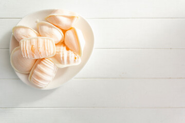 Top view of traditional portuguese sweet called Ovos Moles de Aveiro in white wooden table with copy space
