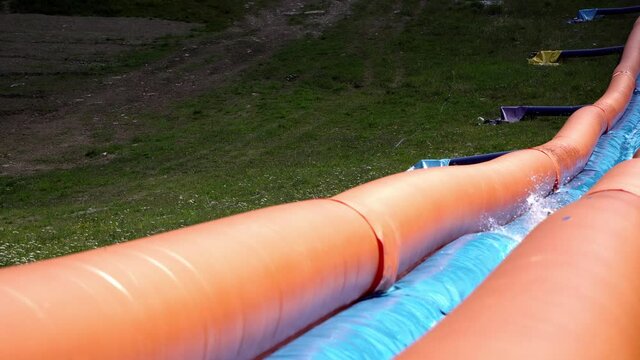 Water slide tubing on longest inflatable waterslide in Bansko, Bulgaria.Enjoying the 300 metre long inflatable, water slide